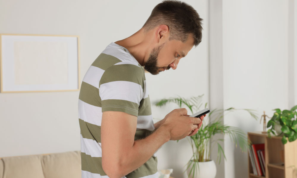Man bent over phone causing forward head posture
